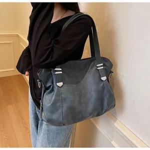 Detail of soft gray-blue leather tote bag with silver hardware and shoulder straps