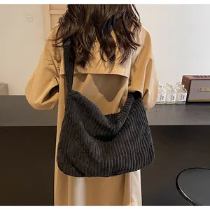 Close-up of black corduroy tote bag showing textured fabric and wide shoulder strap