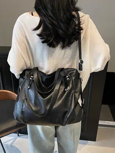 Large black vintage faux leather tote bag with rivets and adjustable shoulder strap