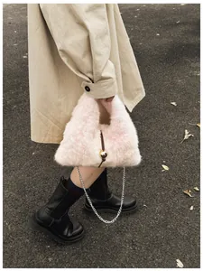 Nahaufnahme der rosa Plüsch-Handtasche mit elegantem Goldkugel-Anhänger und Metallkette