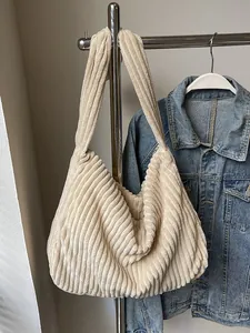 Beige corduroy tote bag with large capacity hanging on a hanger for daily casual style