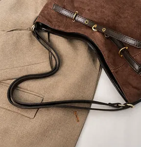 Detail der Wildleder-Einkaufstasche mit braunem Lederriemen und Goldringen
