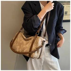 Detailed view of beige canvas bucket bag with brown leather strap and vintage finish