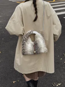 Plüschtasche mit Hirschmuster und Goldanhänger an Model im beigen Herbstmantel getragen