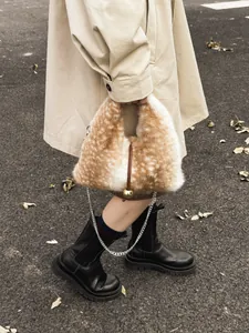 Plüschtasche mit Hirschmuster, Metallkette und Goldperle, kombiniert mit beigem Trenchcoat