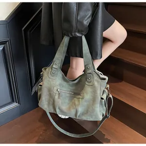 Detailed view of a green vintage tote bag with metal rivets and multi-pocket design