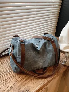 Large capacity vintage denim Boston bag with brown leather straps on wooden surface