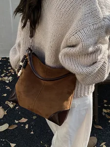 Bolso tote grande de ante marrón con detalles de cuero y colgante de cuentas de madera