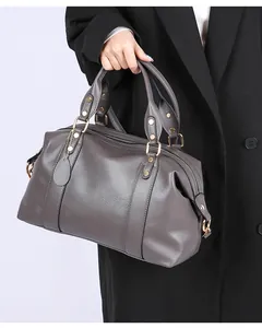Detail of dark grey litchi grain leather tote bag with gold metal studs and handles