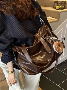 Large dark brown oil wax leather tote bag with shoulder strap and plush charm