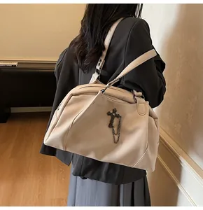 Detailed macro of creamy white lychee leather tote bag with gothic cross and metal chain