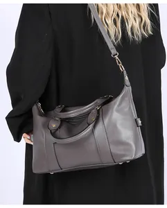 Detail view of the gray leather tote showing lychee texture and gold metal feet