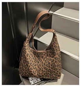 Detailed view of leopard print hobo bag with dark brown leather straps and canvas texture