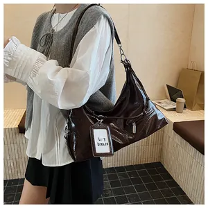 Detail of glossy dark brown shoulder bag with silver zippers and lazy breeze tag