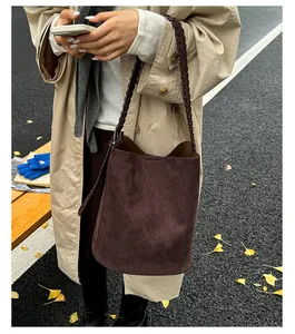 Detail der dunkelbraunen Wildleder-Beuteltasche mit handgewebtem Seilschultergurt und Retro-Look