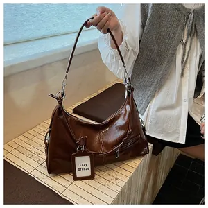 Detail of dark brown glossy hobo bag with silver rings and Lazy Breeze decorative tag