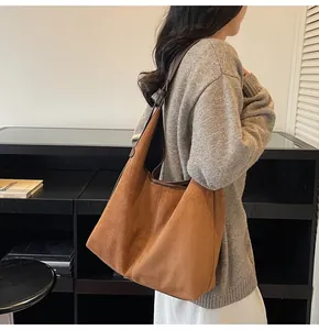 Side view of a large leopard print hobo bag worn by a model in a modern room