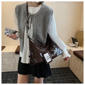 Close-up of dark brown oil wax leather shoulder bag with silver metallic buckle detail