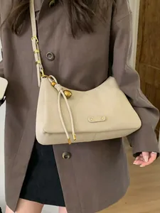 Minimalist oatmeal leather shoulder bag for women with gold hardware and knot detail