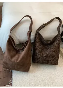Detail view of large hobo bags in brown suede and leopard print with gold hardware