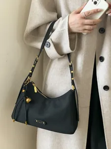 Minimalist black nylon hobo bag for women with gold hardware and tassel pendant