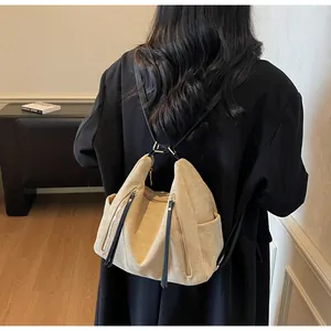 Dettaglio dello zaino in pelle scamosciata beige con cerniere verticali e spalline nere