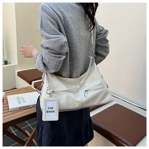 Detail of a creamy beige hobo bag with natural leather texture and stylish card tag