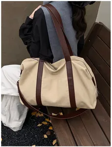 Detalle del bolso tote de lona vintage con asas de cuero y correa ajustable en modelo
