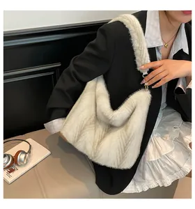 Détail du sac cabas en fausse fourrure blanche montrant la texture et l'anneau en métal