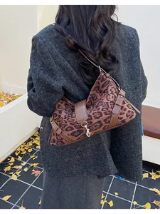 Détail du sac bandoulière léopard en daim avec sangle en cuir et boucle en métal doré