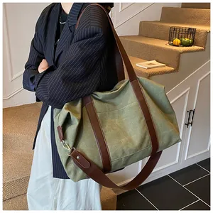 Detalle del bolso tote de lona verde oliva con asas de cuero y texturas resistentes
