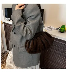 Close-up of soft dark brown faux fur cloud bag with elegant silver chain strap