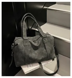 Detail of grey large capacity tote bag with reinforced stitching on a staircase