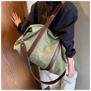 Primer plano de un bolso tote de lona verde oliva con correas de cuero marrón