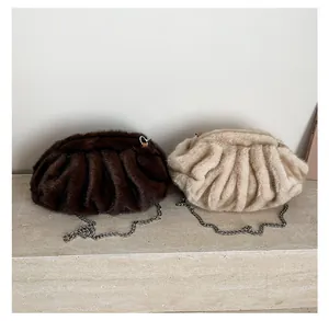 Detailed close-up of plush ruched cloud bags in coffee and beige with silver chains