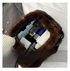 Internal capacity of the plush shell crossbody bag showing phone and cosmetics