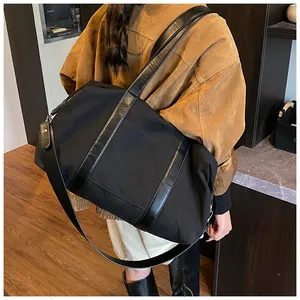 Detalle de bolso tote de lona negra con correas de cuero y herrajes metálicos duraderos