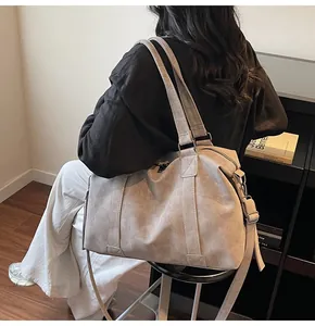 Detailed view of grey high-capacity tote bag with adjustable strap shown on model