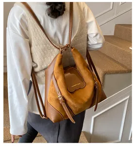 Detail eines Vintage-Rucksacks aus braunem Wildleder und Leder mit goldenem Schriftzug