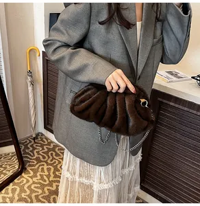 Dark brown plush cloud bag with chain strap shown in a stylish lifestyle setting