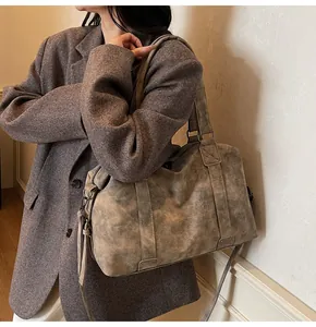 Detail view of large grey-brown vintage tote bag with wide handles and tassel zipper decor