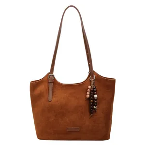 Brown suede tote bag for women featuring decorative beads and an adjustable shoulder strap