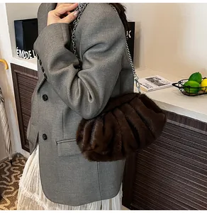 Close-up of fluffy dark brown faux fur cloud bag with elegant silver chain strap detail