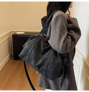 Detail view of large charcoal tote bag with suede texture and adjustable shoulder strap