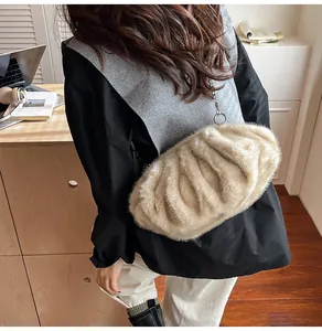 Close-up of a plush beige cloud bag featuring soft faux fur texture and elegant gold chain