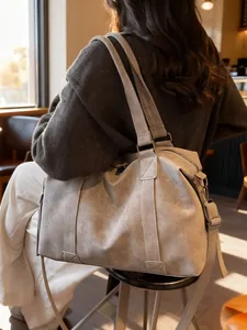 Stylish large capacity grey tote bag shown on model in a cozy indoor cafe setting