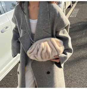 Detail of beige faux fur cloud bag with soft pleats and thin metal chain strap on grey coat