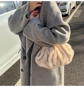 Detail of beige faux fur cloud bag with a chunky silver chain strap on wool coat