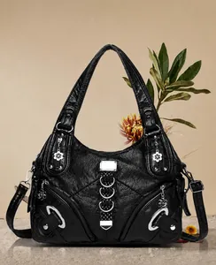 Dettaglio borsa a spalla plissettata nera con fibbie argentate e tasche con zip