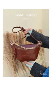 Detailed shot of vintage brown leather bag featuring golden chain and tassel zipper puller